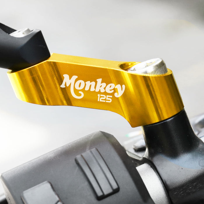 Honda Monkey 125 mirror extender riser by MC Motoparts, showing installed side mirror extension on motorcycle handlebar.