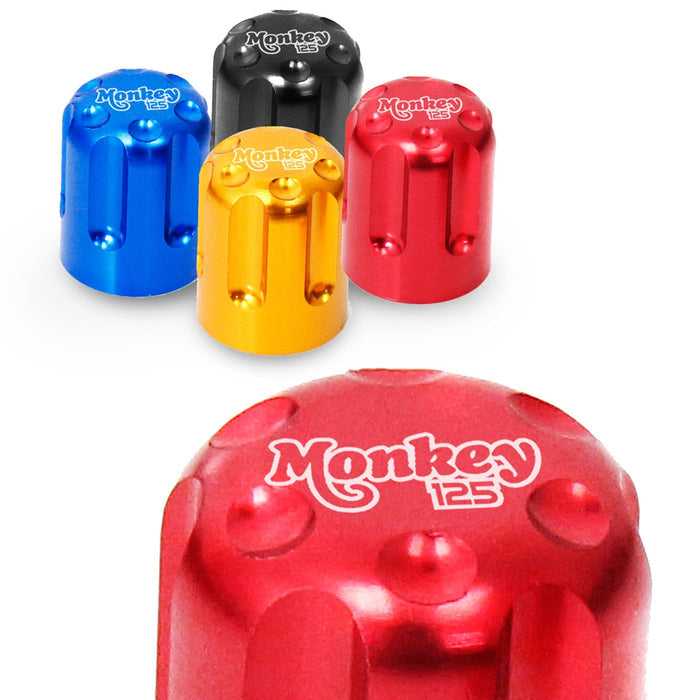 Red Honda Monkey 125 engraved logo tire valve stem caps by MC Motoparts shown on a vehicle.