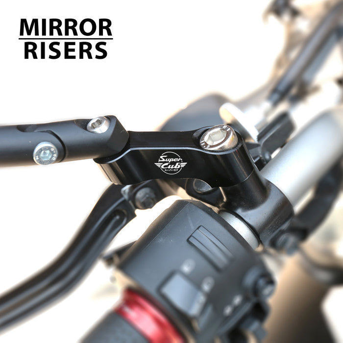 Black Honda Super Cub C125 mirror extender by MC Motoparts, showing the engraved logo and installation on the side mirror.
