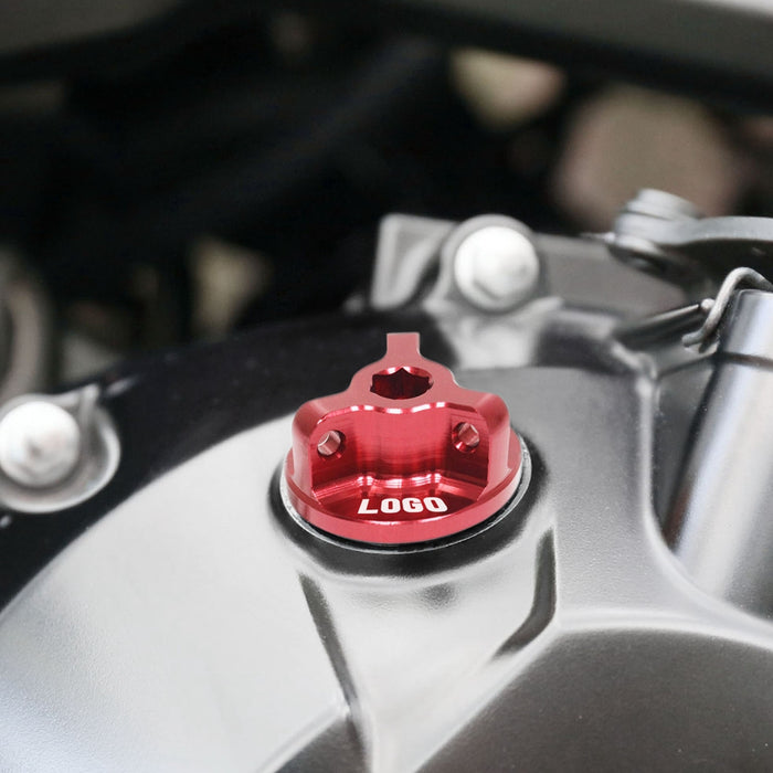 Honda CBR500R 2013-2025 oil filler cap by MC Motoparts, engraved logo, metallic finish, installed on motorcycle engine.