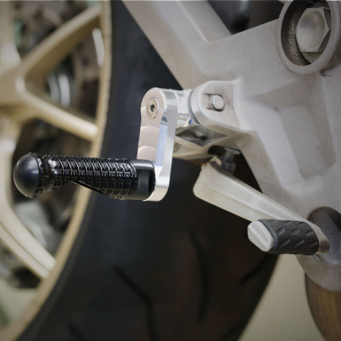 Black MC Motoparts 40mm extension front foot pegs installed on Honda CBR600F and CBR600RR motorcycle.