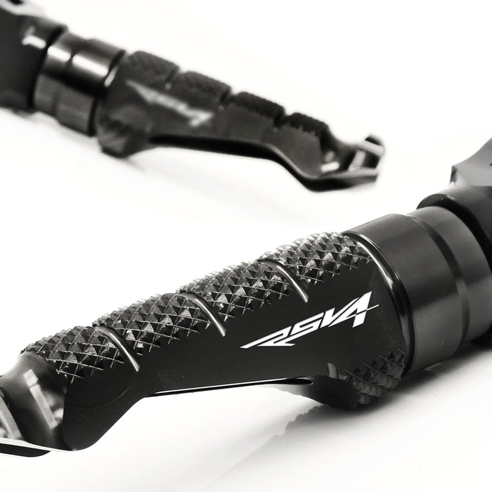 Front MC Motoparts R-FIGHT engraved logo foot pegs for Aprilia RSV4 1000 R motorcycle, metal with black finish and textured surface.